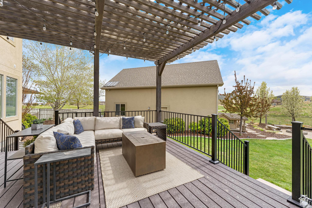 Wooden deck featuring an outdoor hangout area, a lawn, a pergola, and a fenced backyard