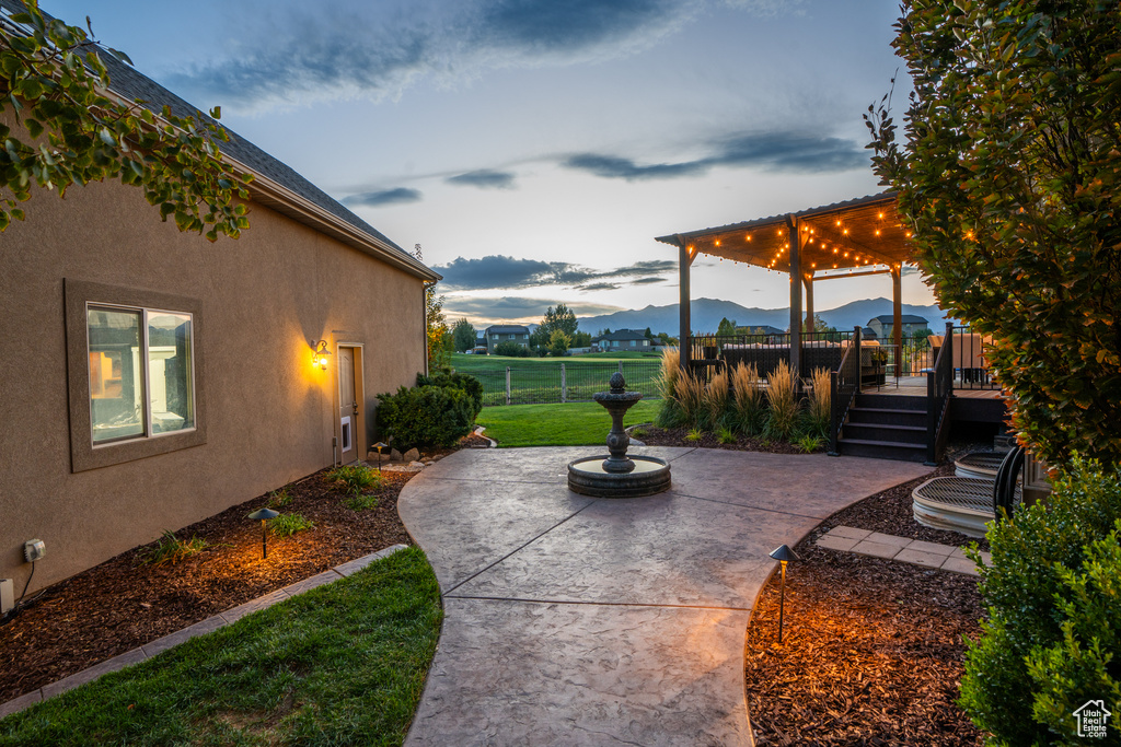 View of patio featuring fence and a deck with mountain view