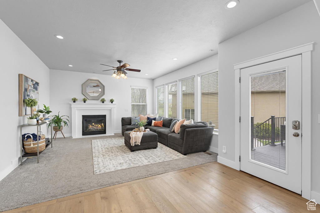 Living room with wood finished floors, a ceiling fan, and recessed lighting