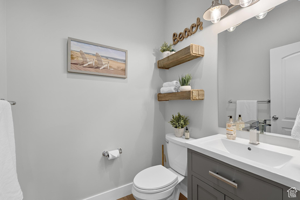 Bathroom featuring toilet, vanity, and baseboards