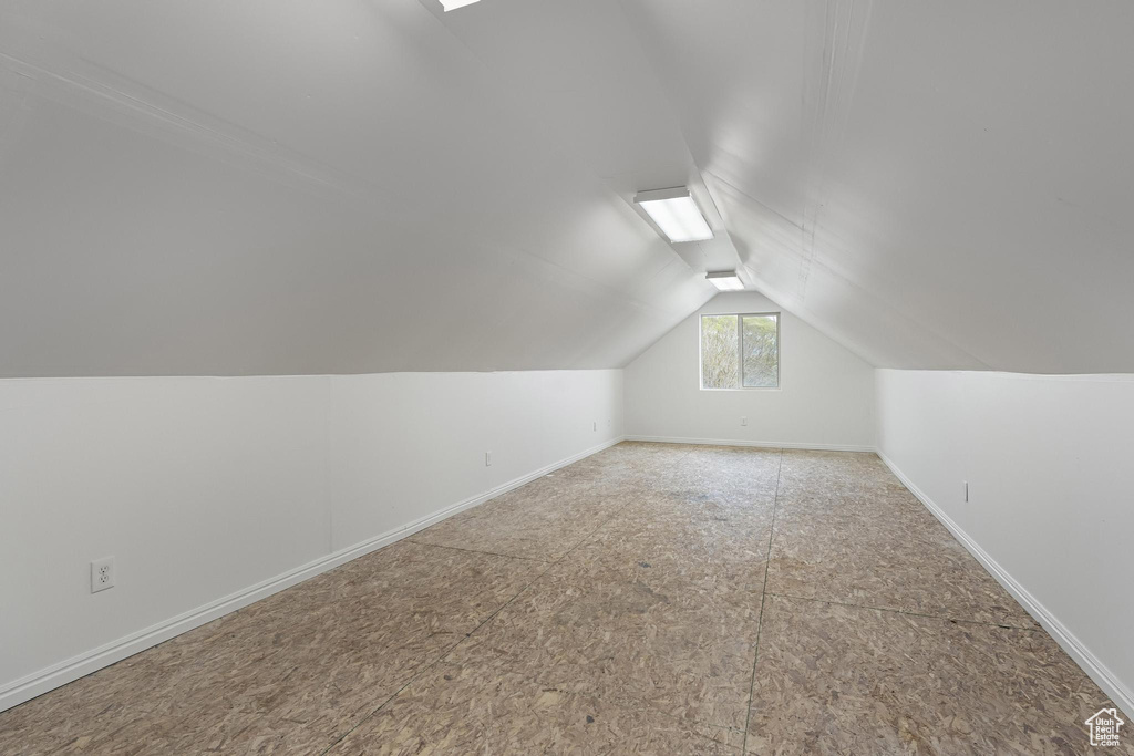Additional living space featuring lofted ceiling and baseboards