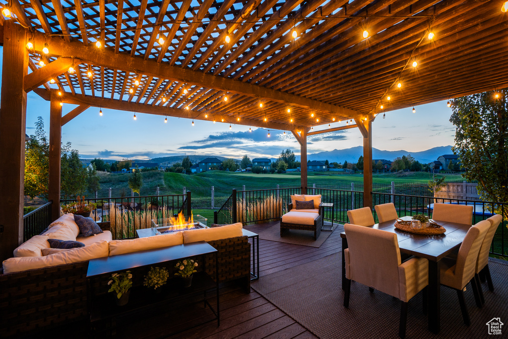 Deck with a mountain view, an outdoor living space with a fire pit, and a pergola