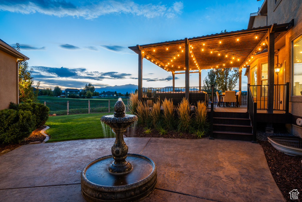 View of patio featuring fence and a deck with mountain view