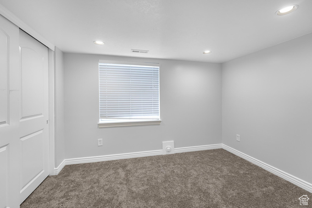 Carpeted empty room with visible vents, recessed lighting, and baseboards