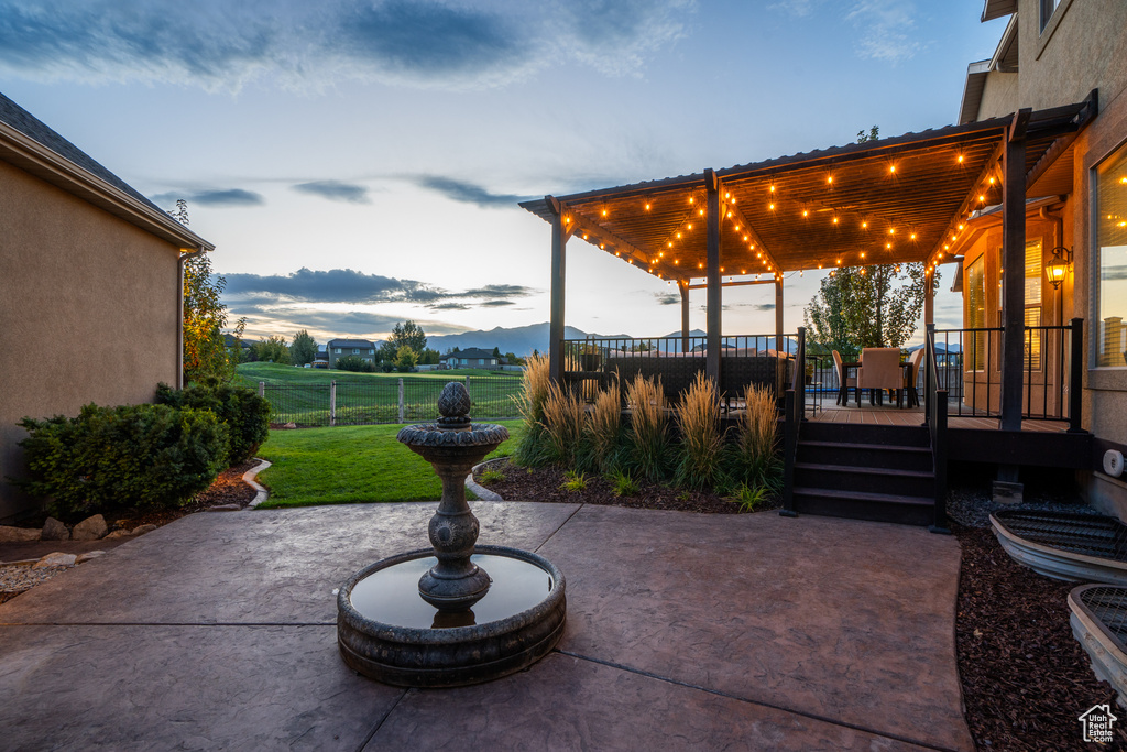 View of patio featuring fence and a deck with mountain view