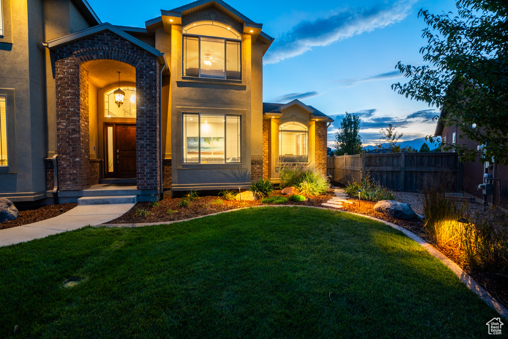View of front of property featuring stucco siding, fence, and a front yard