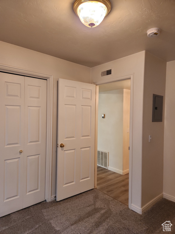 Unfurnished bedroom with electric panel, visible vents, carpet flooring, and baseboards