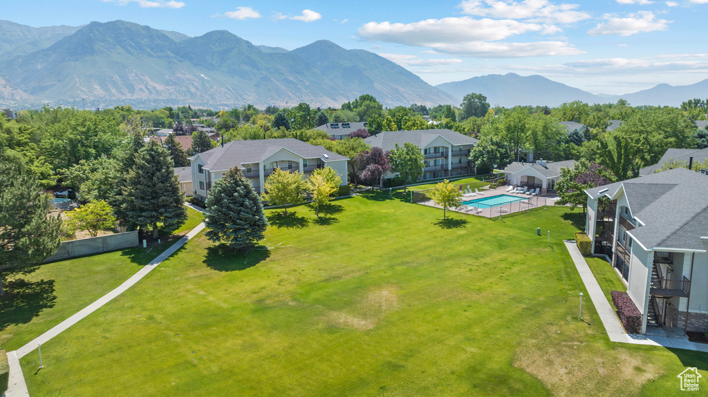 Aerial perspective of suburban area featuring a pool and a mountainous background