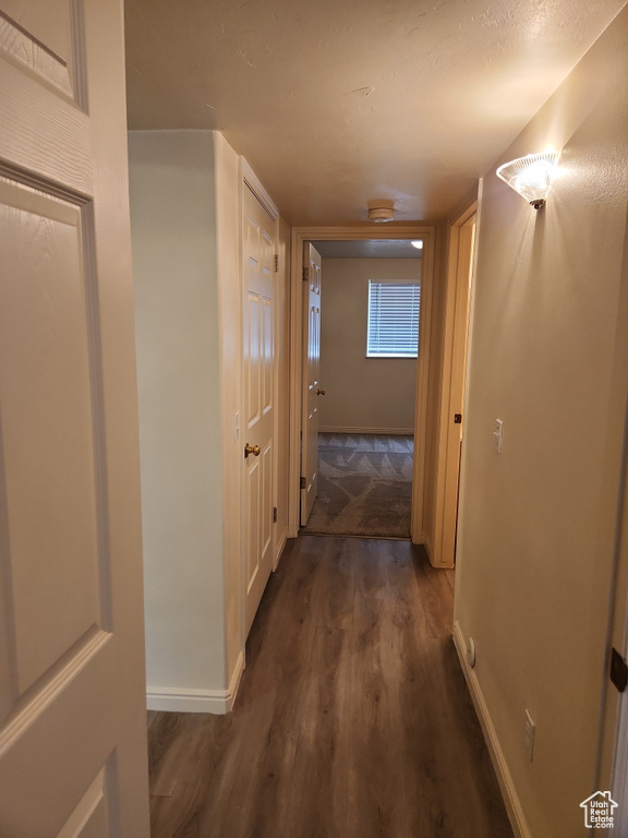 Corridor featuring baseboards and wood finished floors