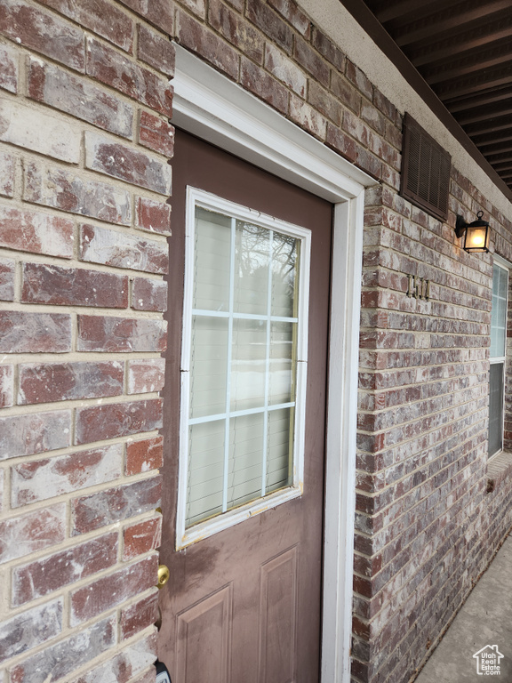 Property entrance with brick siding and visible vents