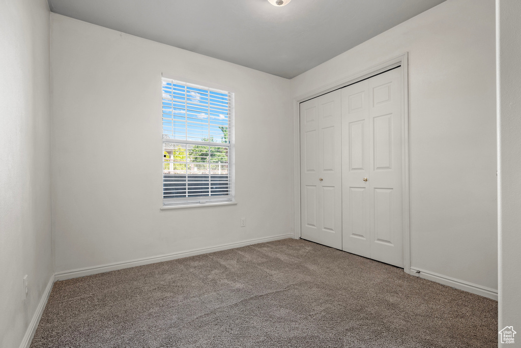 Unfurnished bedroom featuring carpet floors and a closet