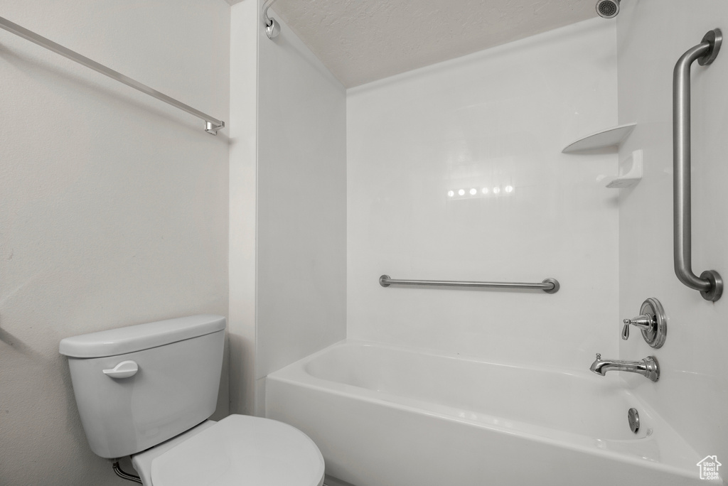 Bathroom with tub / shower combination and a textured ceiling