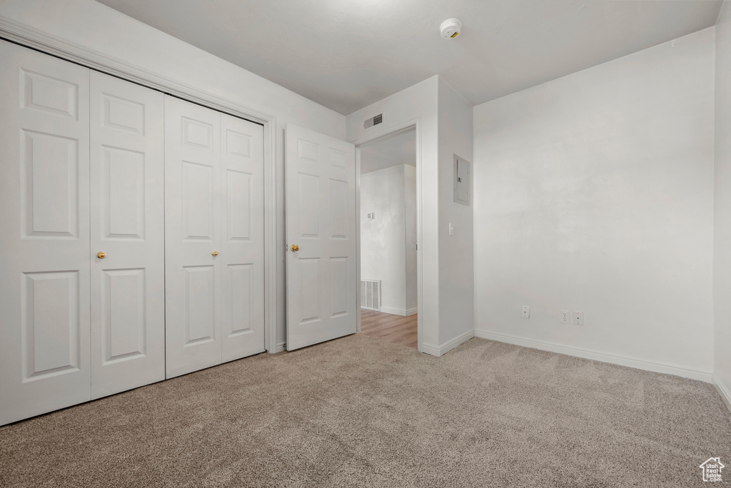 Unfurnished bedroom featuring carpet and a closet