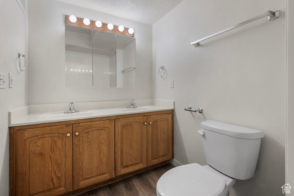 Full bath featuring double vanity and wood finished floors