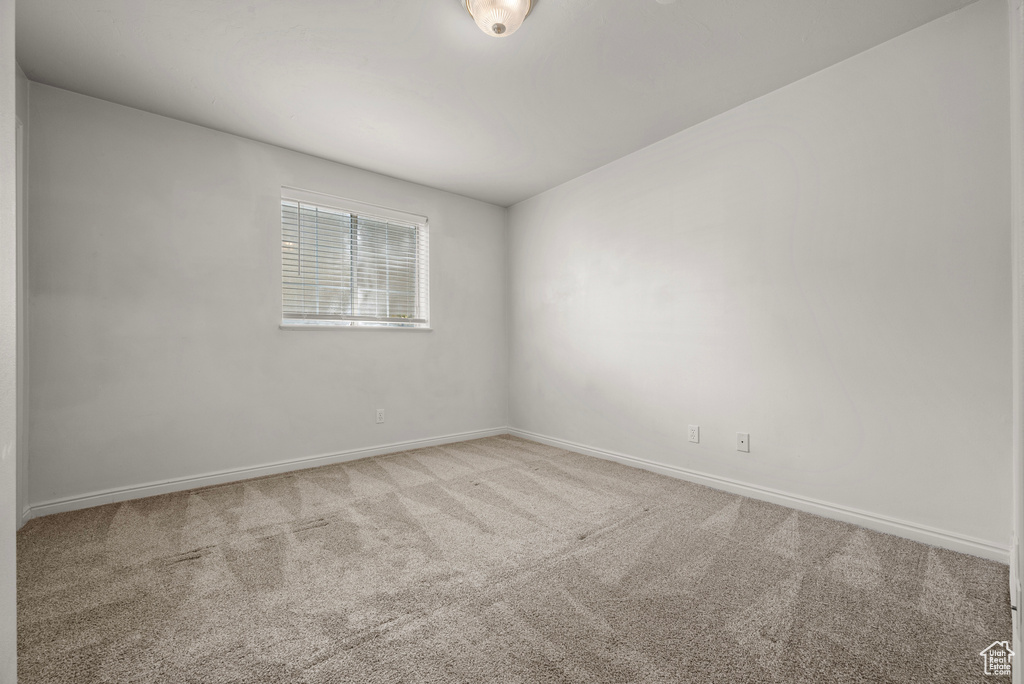 Spare room featuring carpet and baseboards