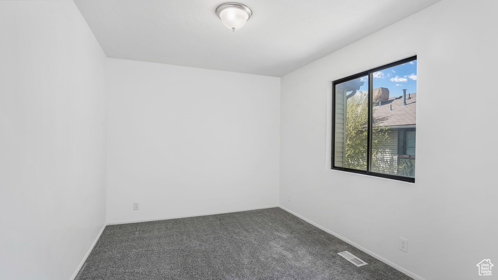 Carpeted empty room featuring visible vents and baseboards