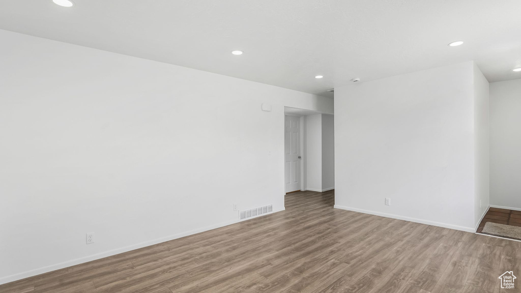 Unfurnished room featuring recessed lighting, visible vents, wood finished floors, and baseboards
