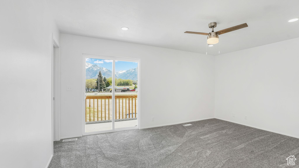 Carpeted spare room featuring recessed lighting, a ceiling fan, a mountain view, and baseboards