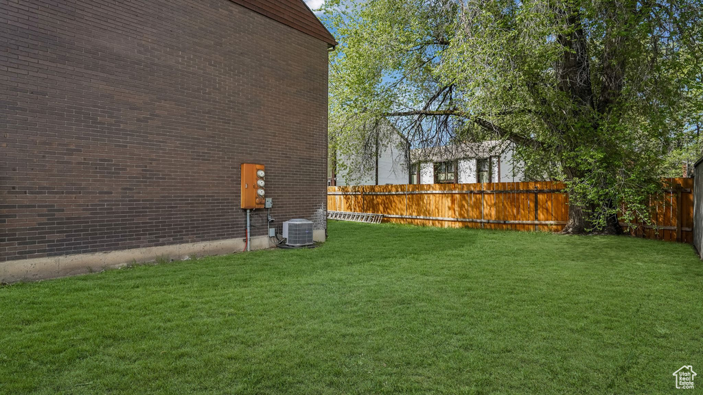 View of yard featuring central AC and a fenced backyard