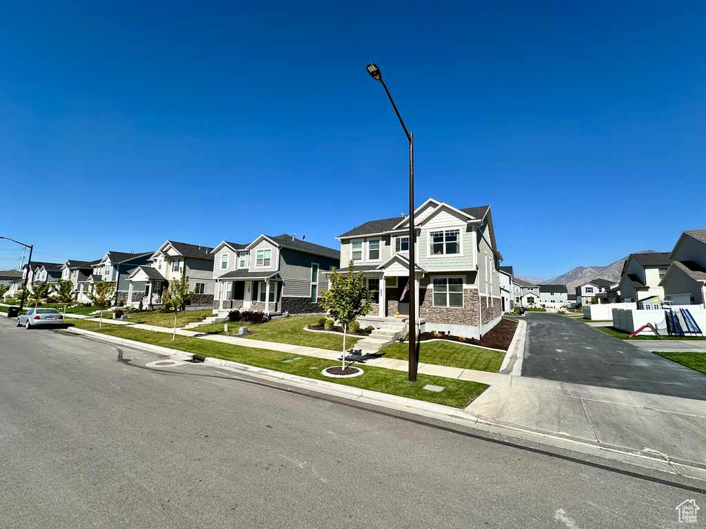 View of front of home featuring a residential view, a front yard, and aphalt driveway