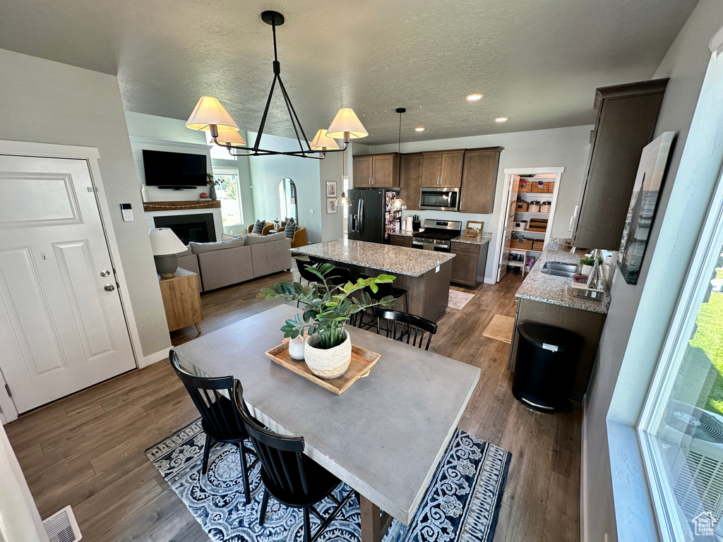 Dining room featuring a fireplace, recessed lighting, visible vents, and dark wood finished floors