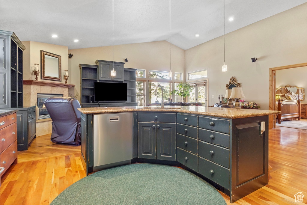 Kitchen with open floor plan, light wood-style flooring, a sink, and vaulted ceiling