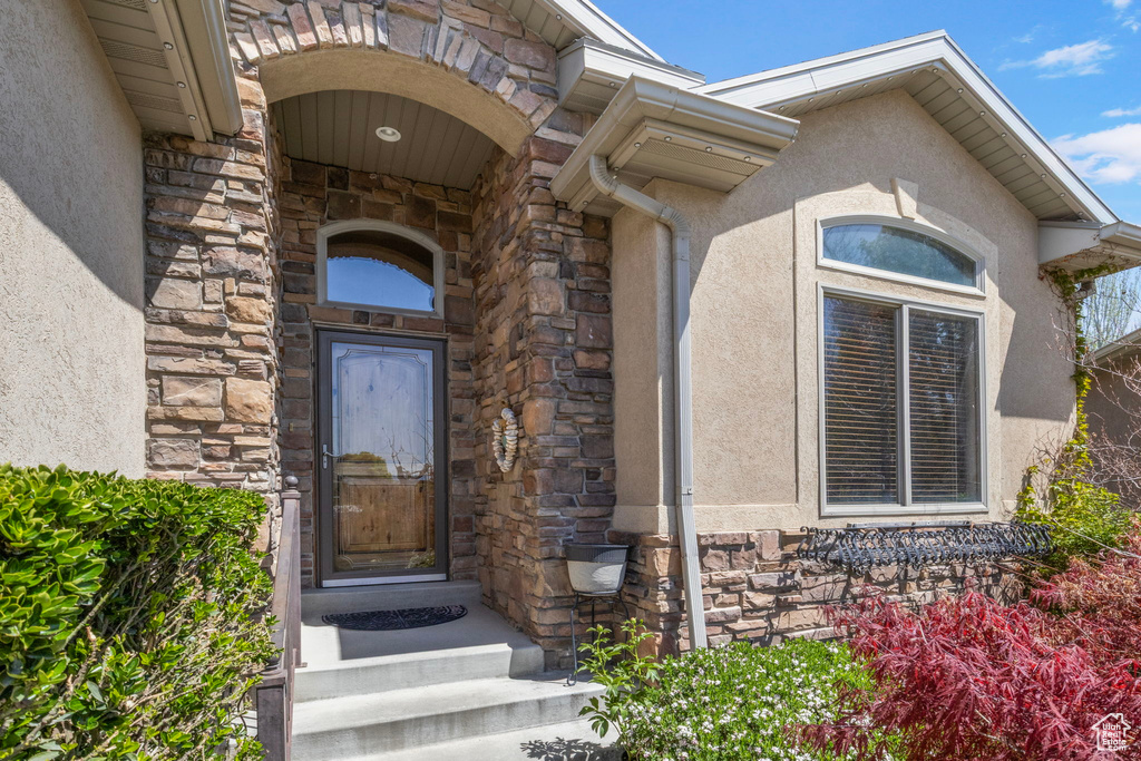 Doorway to property with stone siding and stucco siding