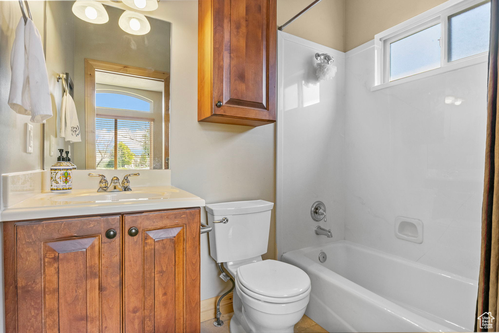 Full bathroom with washtub / shower combination, toilet, and vanity