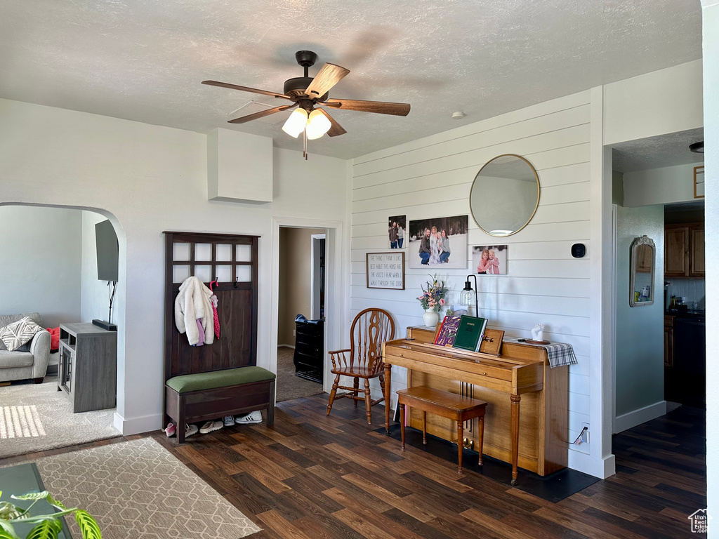 Entryway with arched walkways, ceiling fan, a textured ceiling, and dark wood-style flooring
