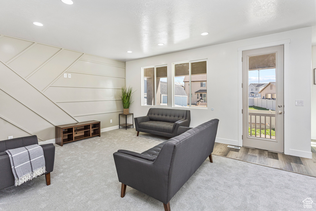 Carpeted living room with recessed lighting and baseboards