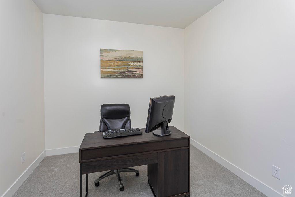 Office area with baseboards and light colored carpet