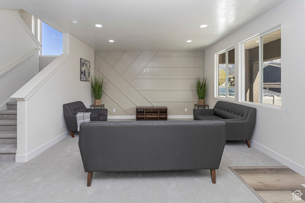 Living room featuring baseboards, stairway, carpet flooring, and recessed lighting