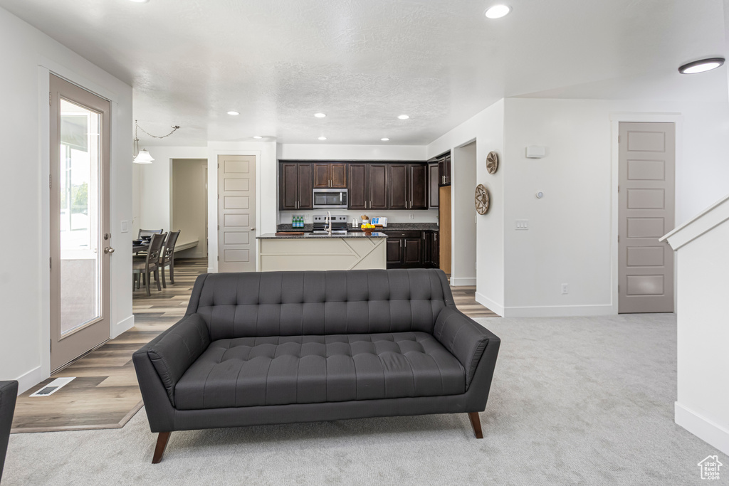 Living room featuring baseboards, recessed lighting, visible vents, and light colored carpet