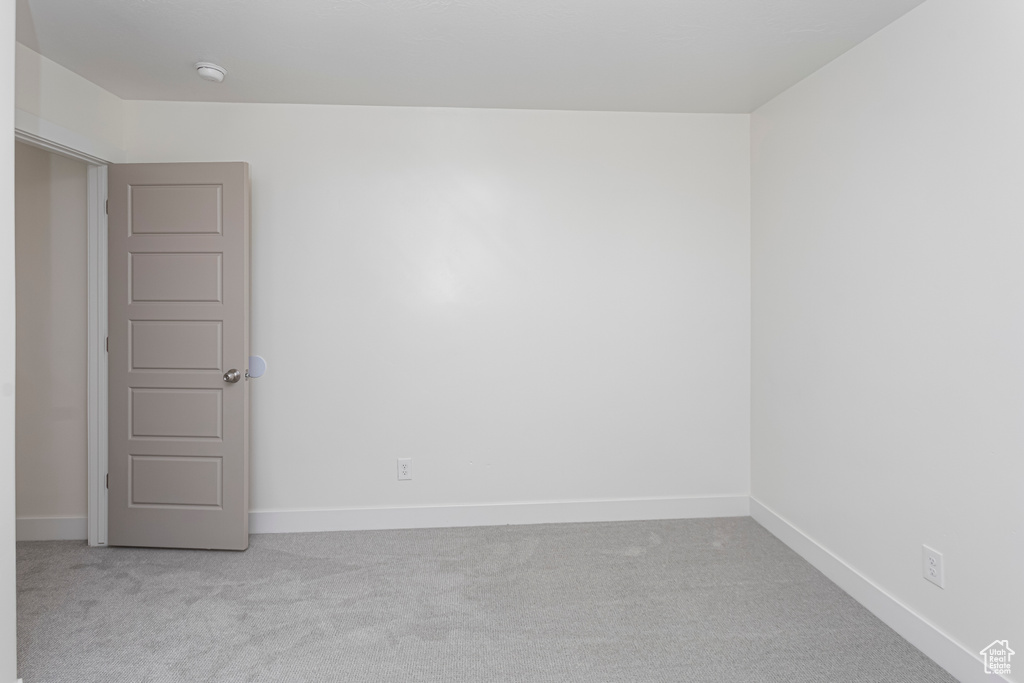 Unfurnished room with baseboards and light carpet