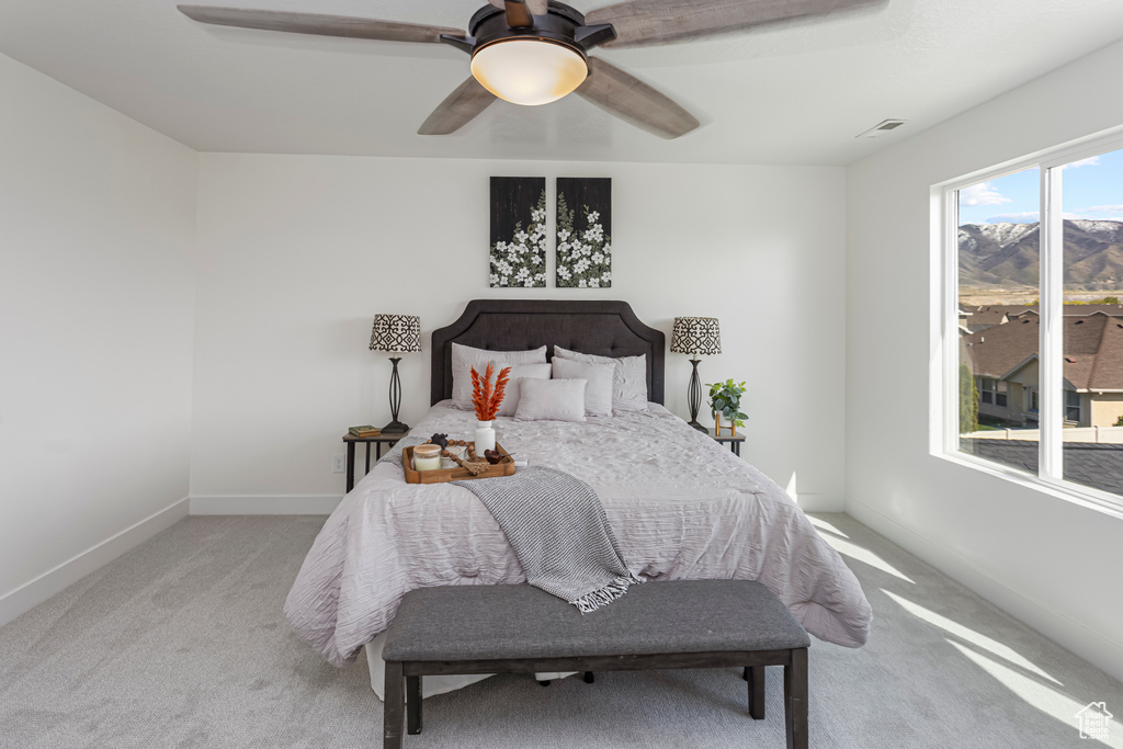 Bedroom with a ceiling fan, visible vents, light carpet, and baseboards