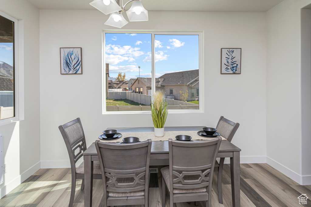 Dining space featuring an inviting chandelier, wood finished floors, and baseboards