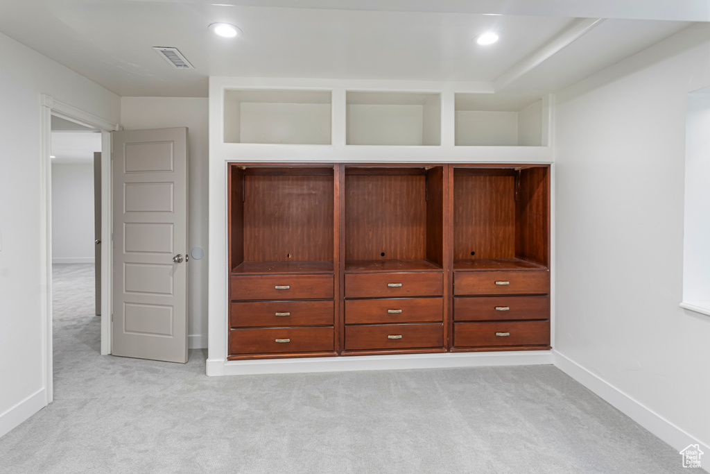 Interior space featuring baseboards, visible vents, light carpet, and recessed lighting