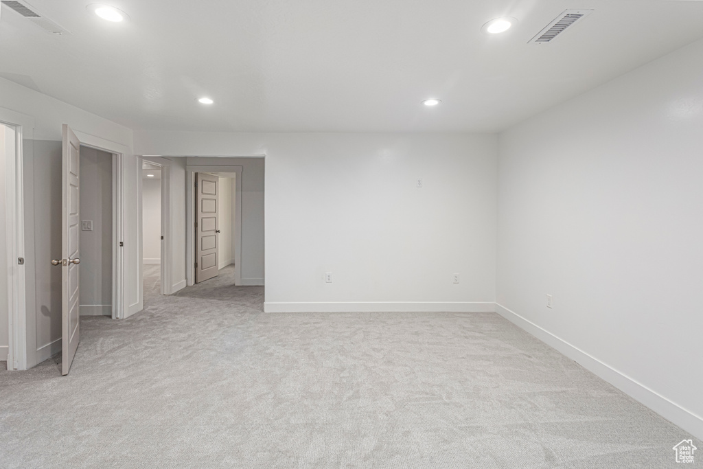 Unfurnished bedroom with light colored carpet, visible vents, recessed lighting, and baseboards