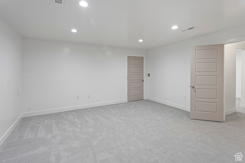 Empty room featuring visible vents, recessed lighting, light carpet, and baseboards