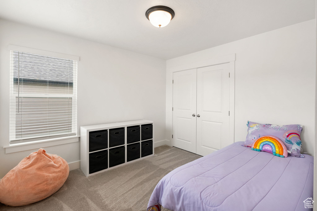 Bedroom featuring baseboards, carpet, and a closet