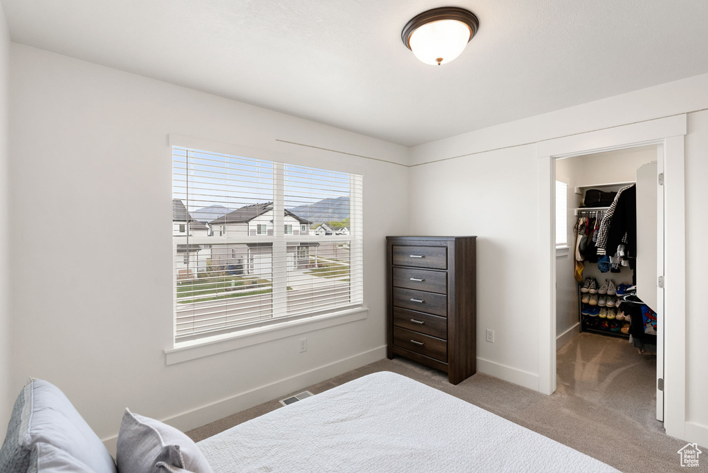 Bedroom with carpet, a spacious closet, visible vents, a closet, and baseboards
