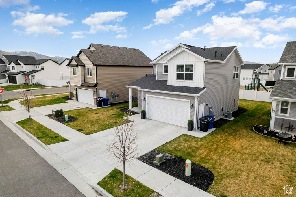 Traditional-style house featuring board and batten siding, concrete driveway, a residential view, and a garage