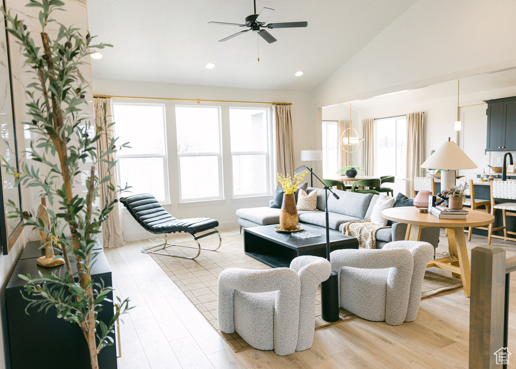 Living room with high vaulted ceiling, recessed lighting, a ceiling fan, and light wood-style flooring