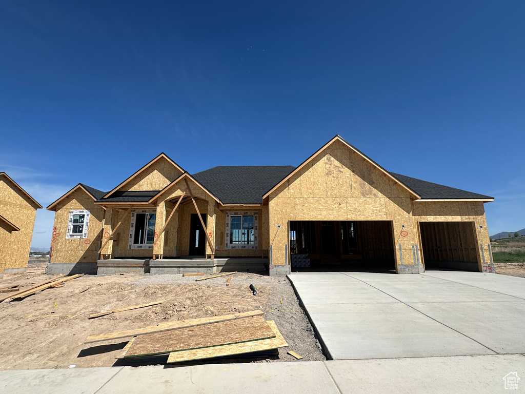 Property in mid-construction with driveway, a porch, and an attached garage