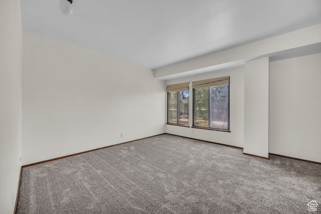 Carpeted empty room with baseboards