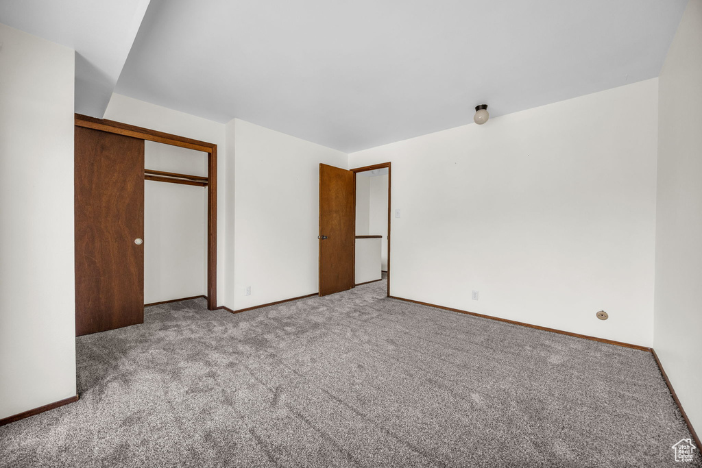 Unfurnished bedroom featuring baseboards, a closet, and carpet flooring