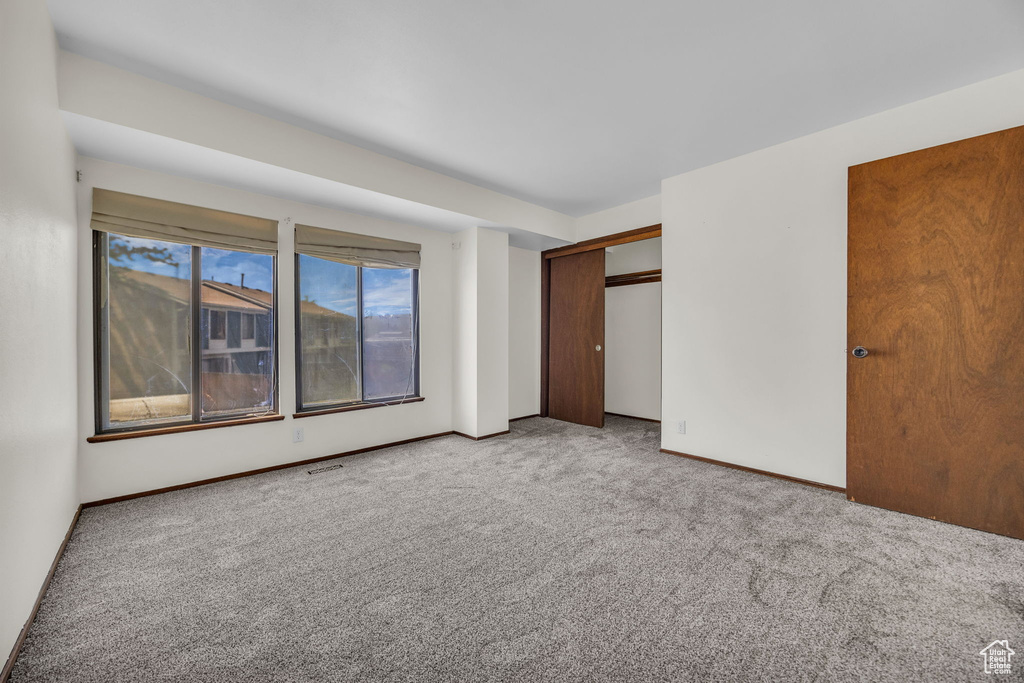 Unfurnished bedroom with a closet, baseboards, and carpet floors