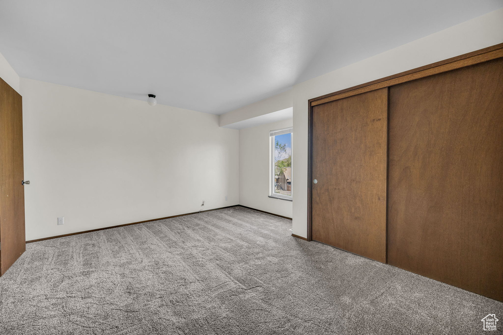 Unfurnished bedroom featuring carpet and a closet