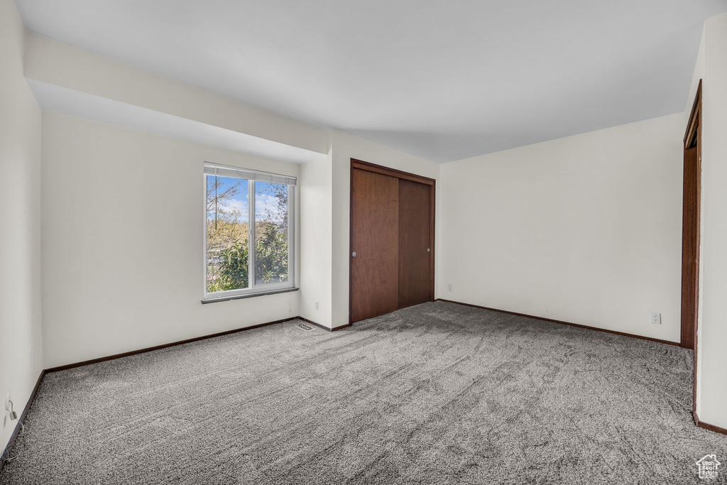 Unfurnished bedroom featuring carpet, baseboards, and a closet