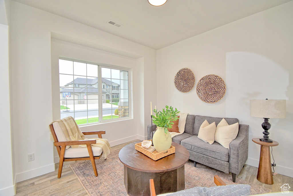 Living area featuring visible vents, light wood-style flooring, and baseboards
